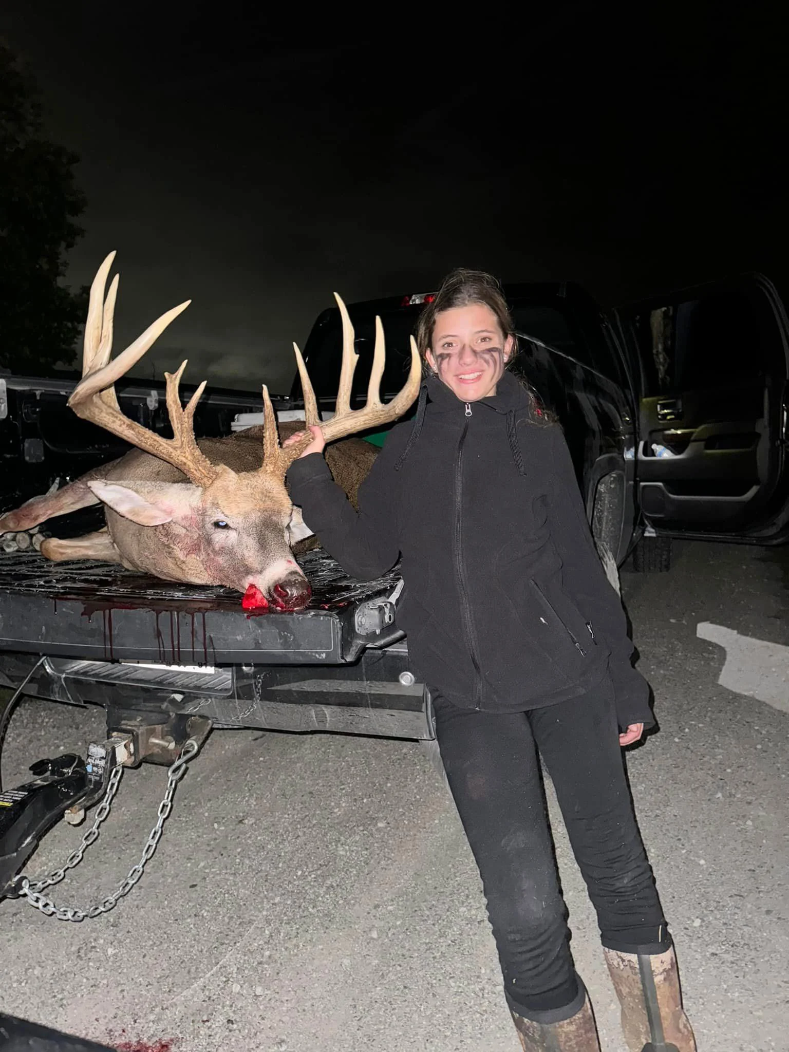 Ava Kirtey stands next to a giant whitetail taken during an Indiana youth hunt. 