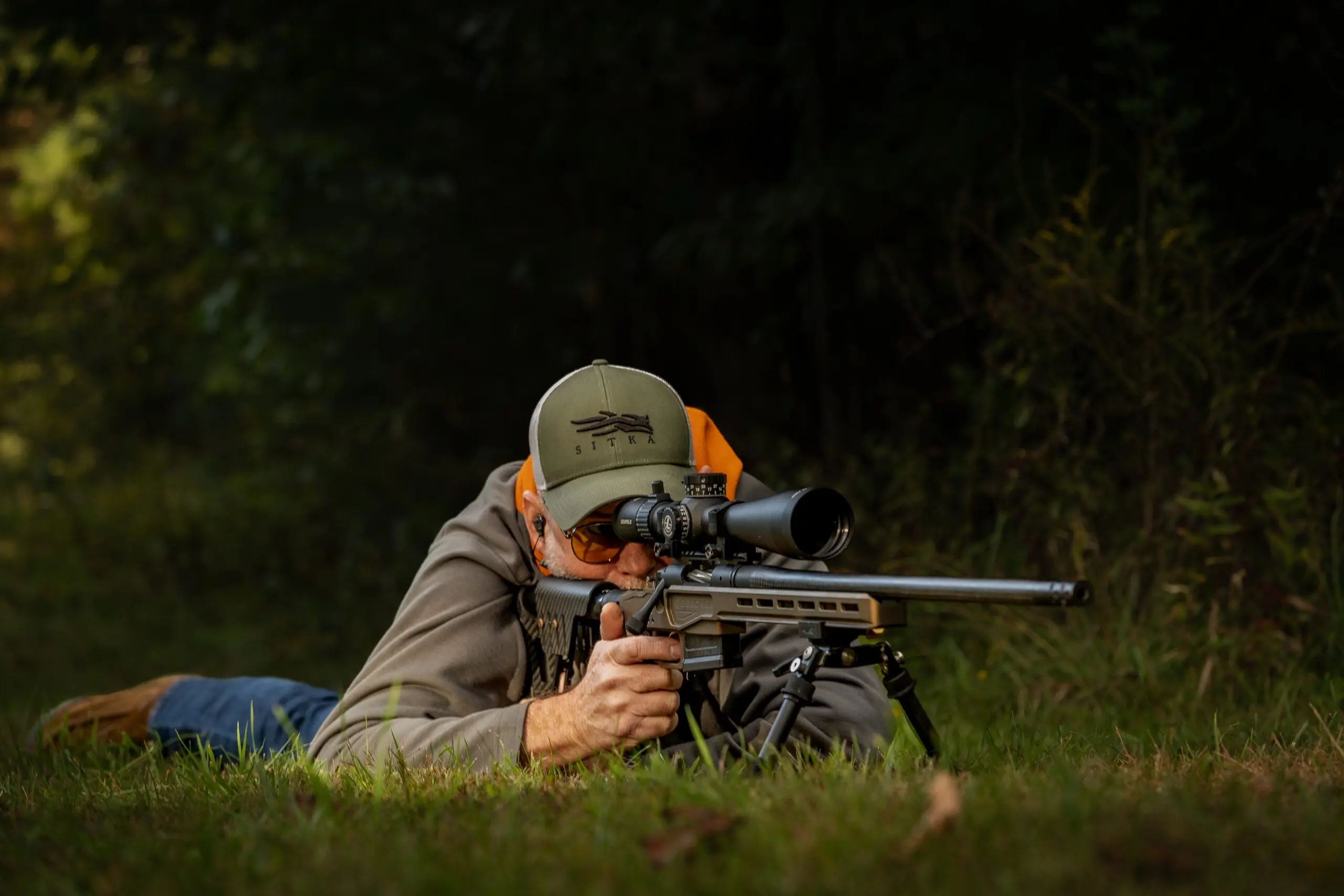 Man in the prone position shooting a rifle.