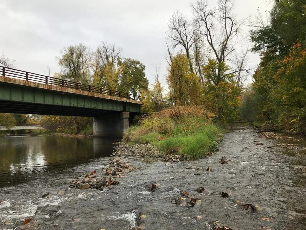 stream running next to a bridge.