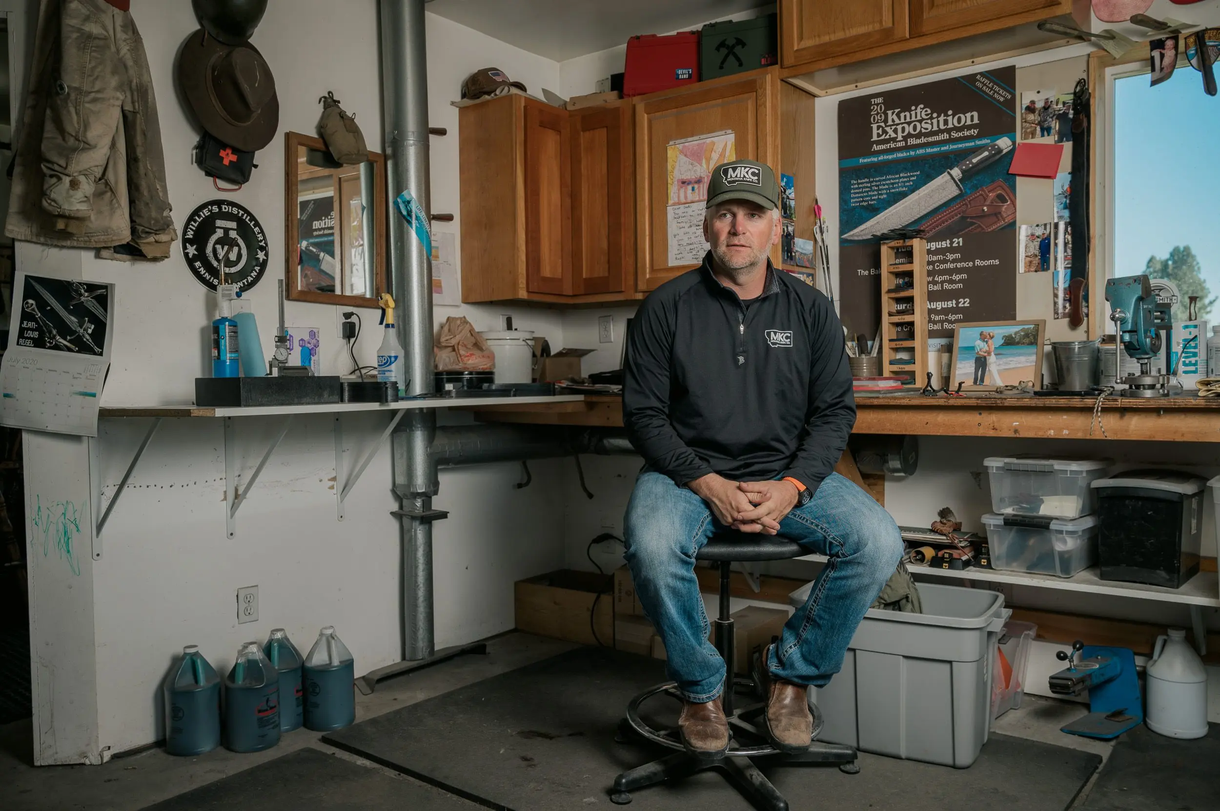 A knife maker pose for photos in his shop. 