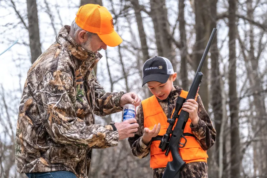 Adult teaching child to handle firearms safely.