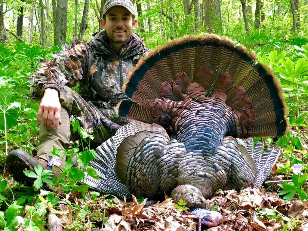 A hunter next to a large public land turkey.