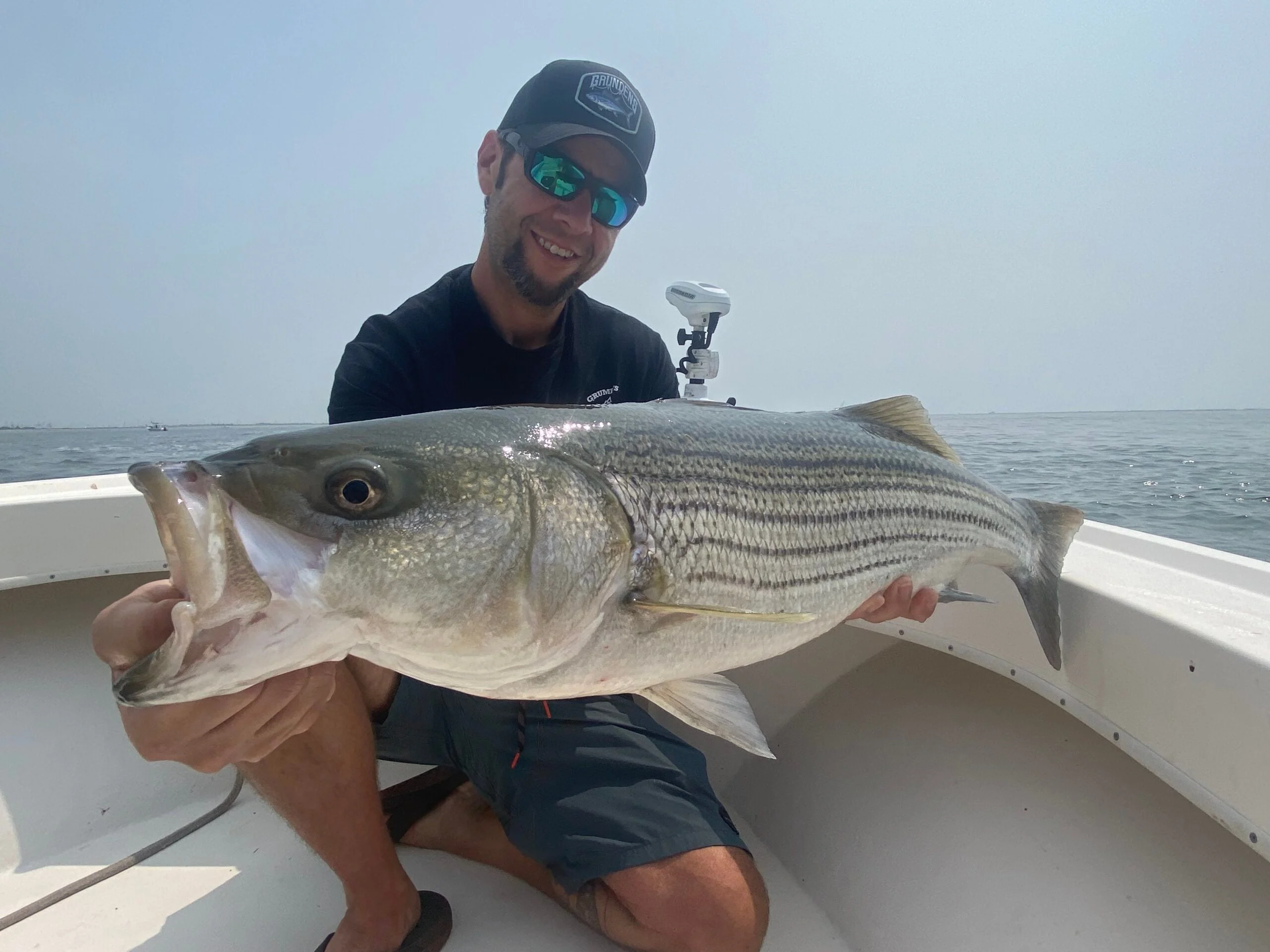 fisherman wearing polarized sunglasses while striped bass fishing