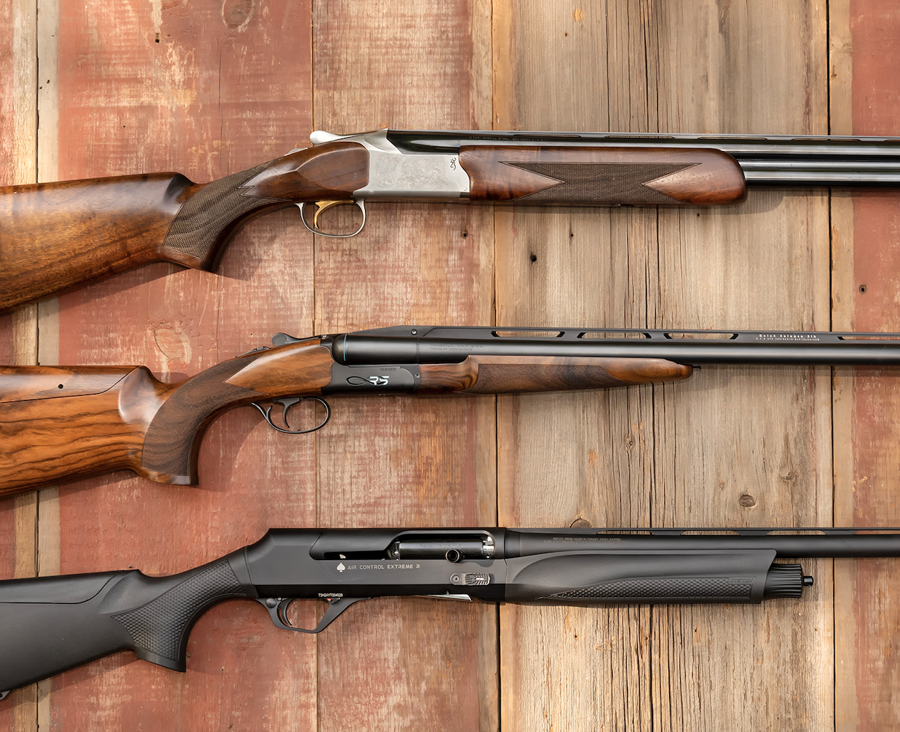 Three of the best shotguns of 2025 resting on barn boards.