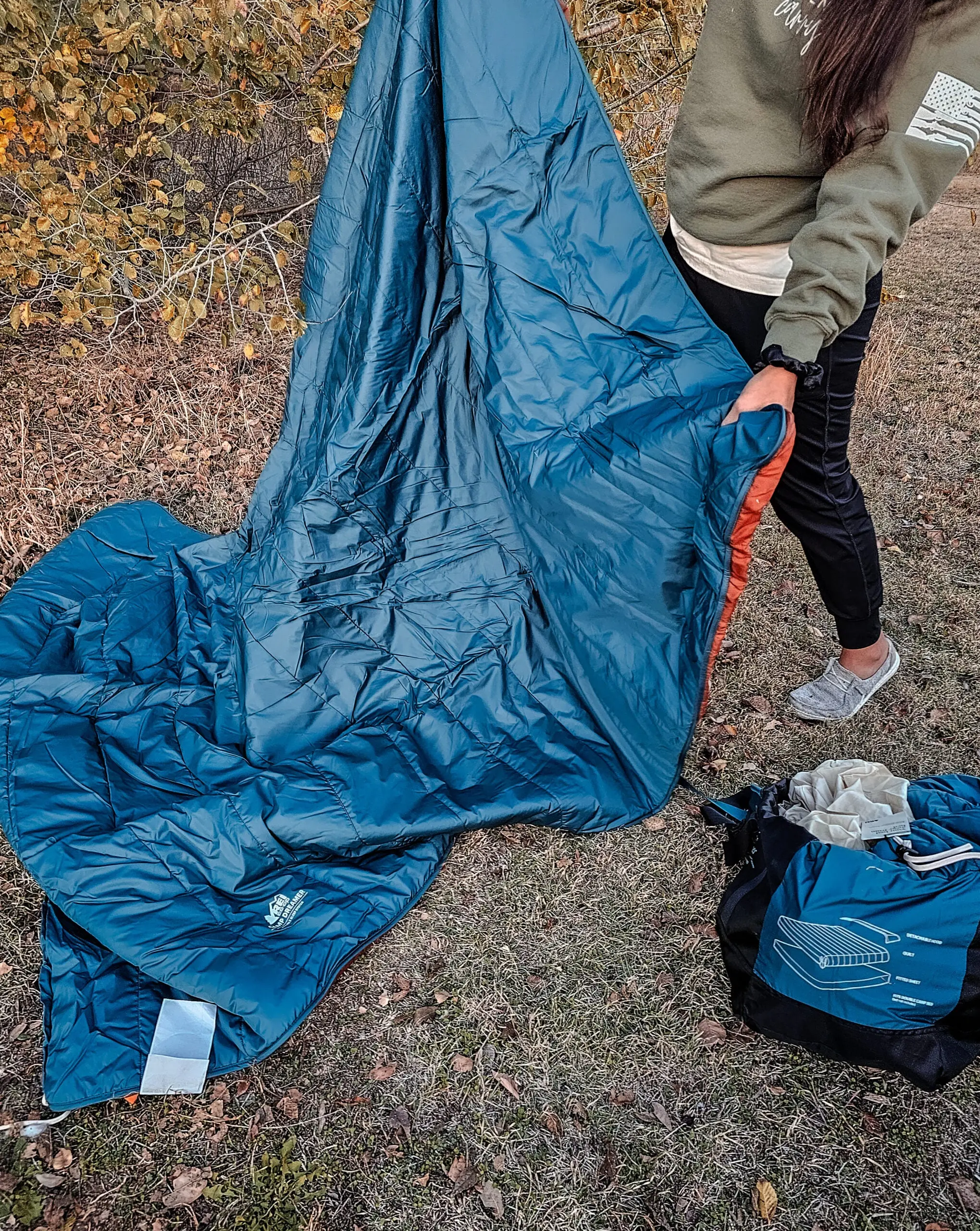 Female camper spreading out REI Camp Dreamer Double Sleeping Bag