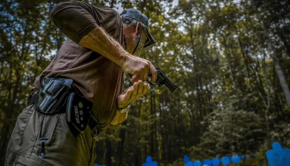 Man shooting a handgun at metal targets.