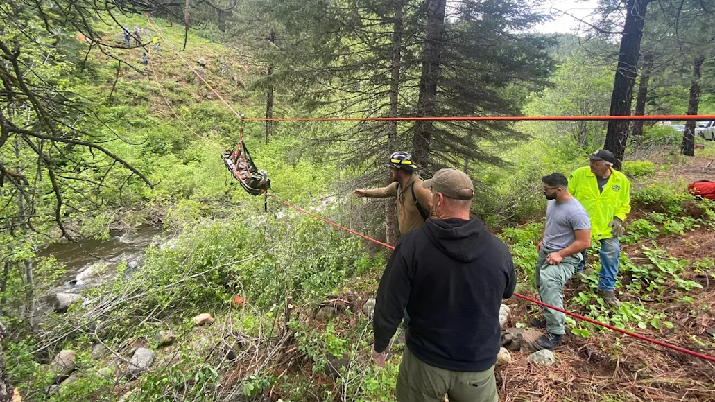 man being lifted in a basket from a car rescue