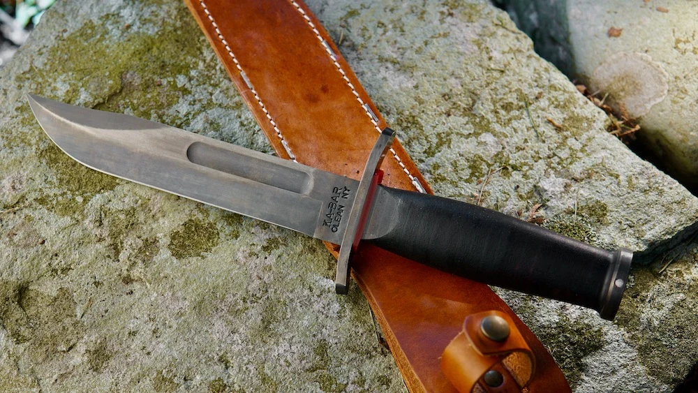 State & Union Red Spacer USN Ka-Bar Bowie Knife lying on rock