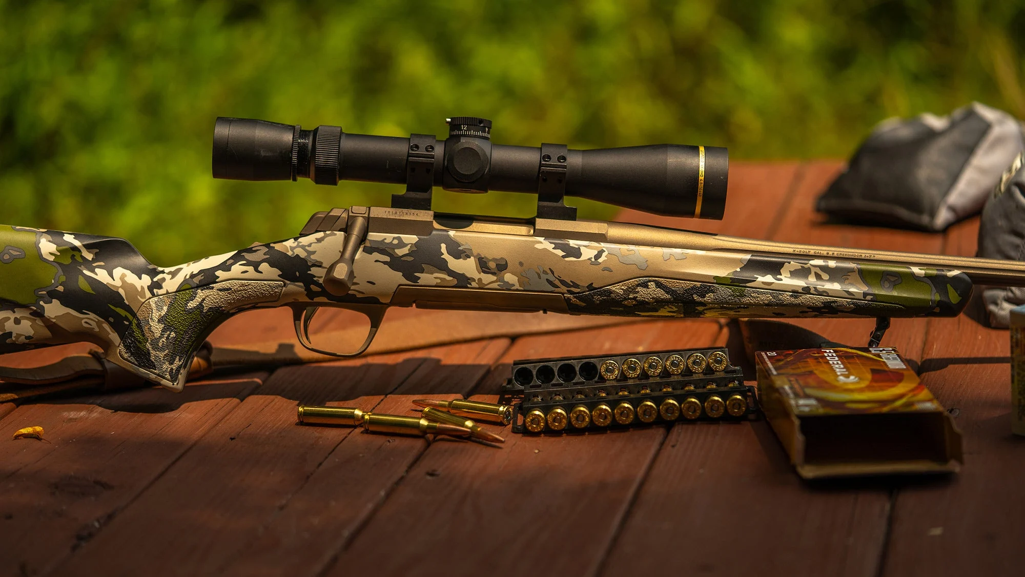 browning rifle rests on table with ammunition in front