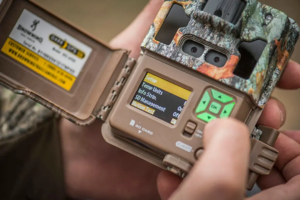 Up-close shot of fingers pushing buttons on a game camera.