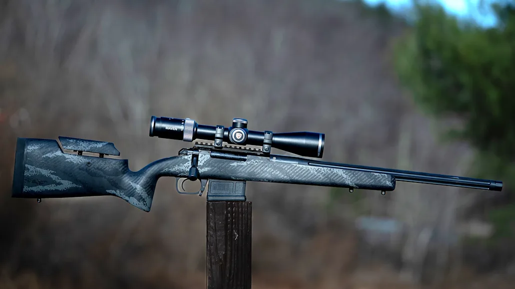 Aero Precision SOLUS Hunter rifle on a post with woods in background