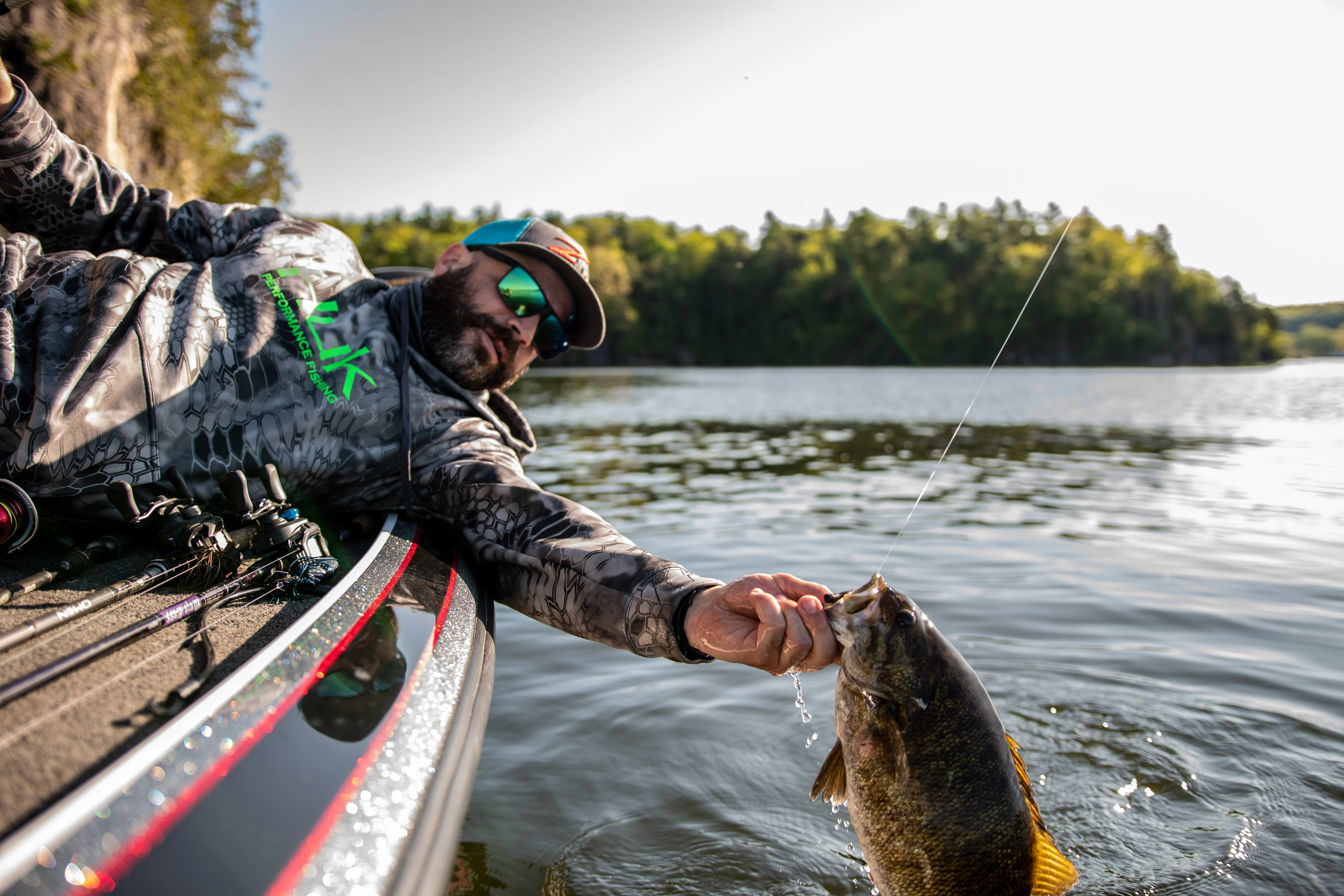Angler holding smallmouth bass over the side of the boat