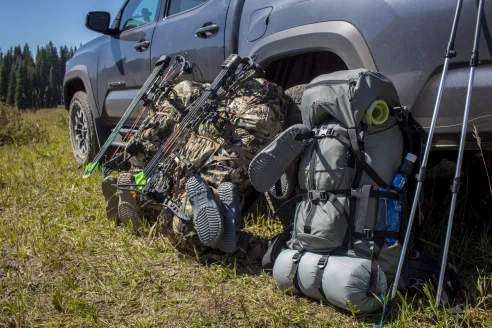 Three hunting packs leaning up against truck