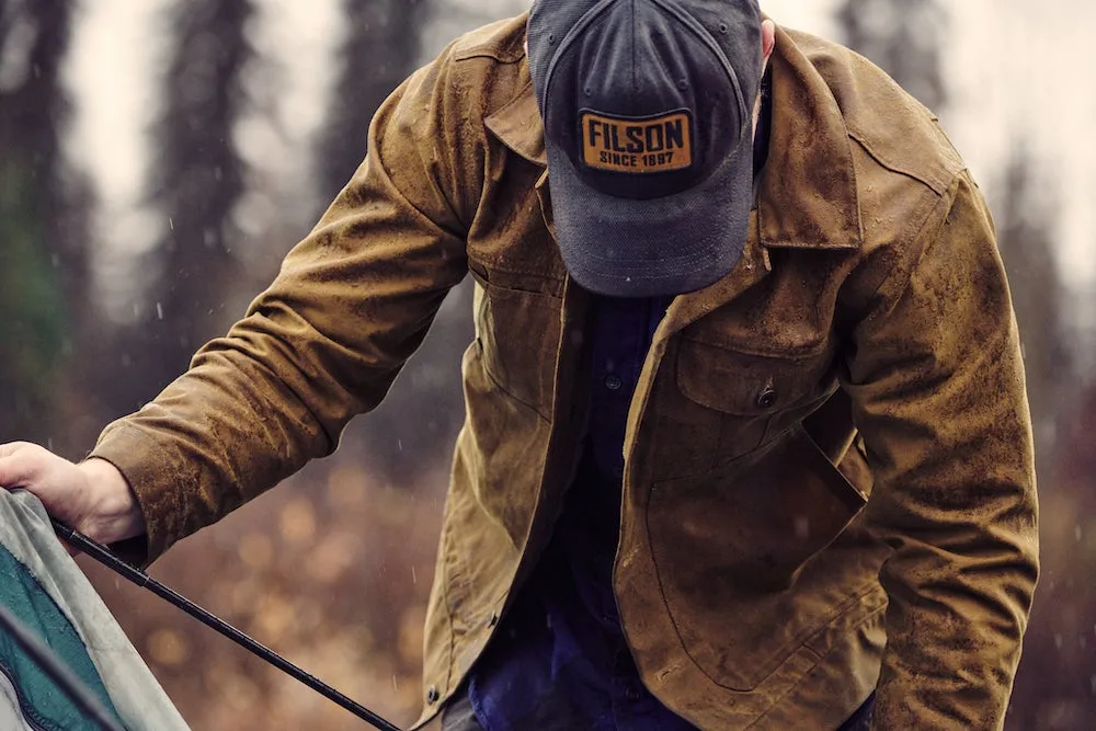 Man wearing Filson hat and jacket while working outdoors