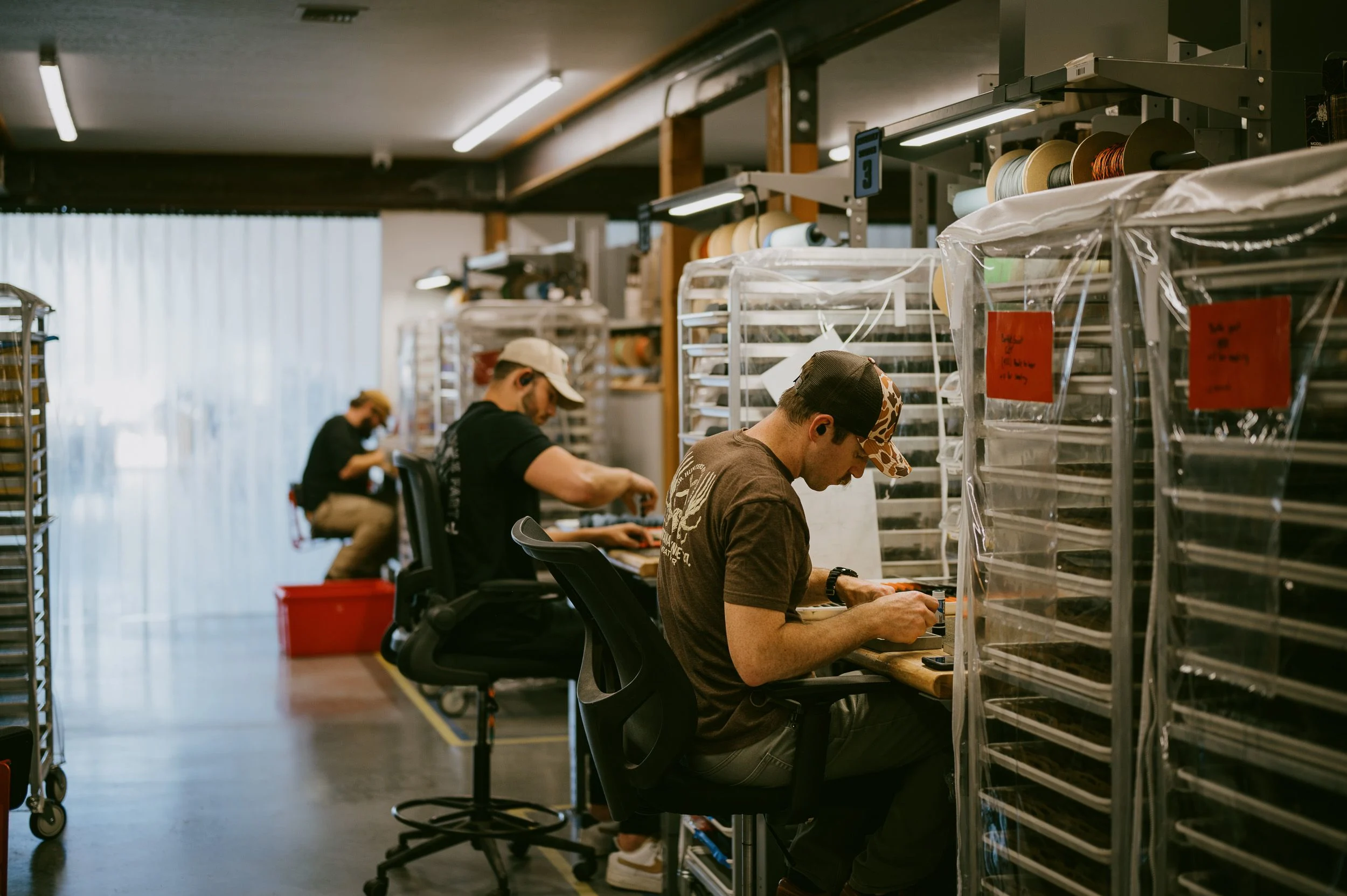 Knife shop workers readying knives for packaging. 