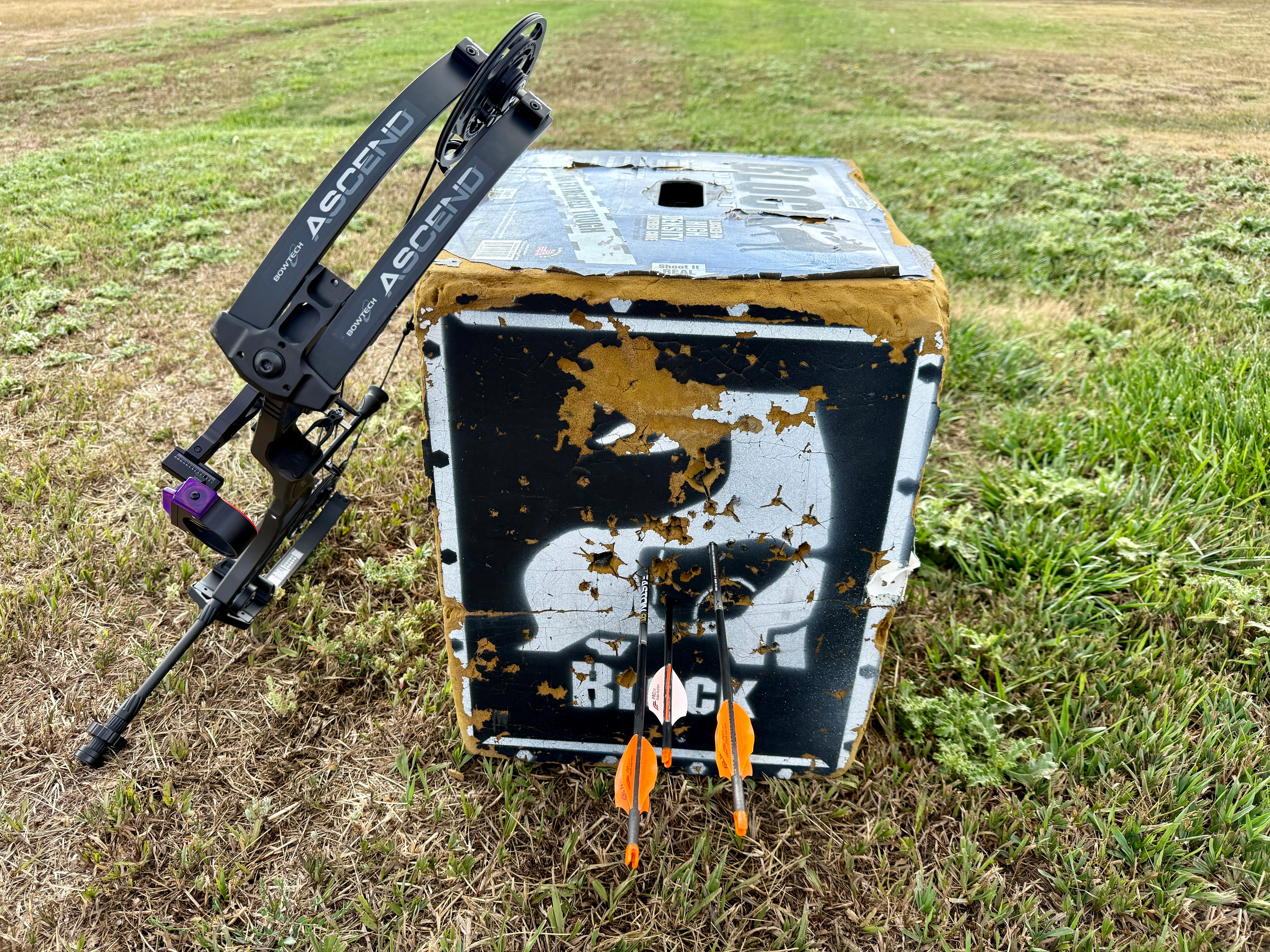 An archery target with a tight group of arrows and the new Bowtech Ascend compound bow.