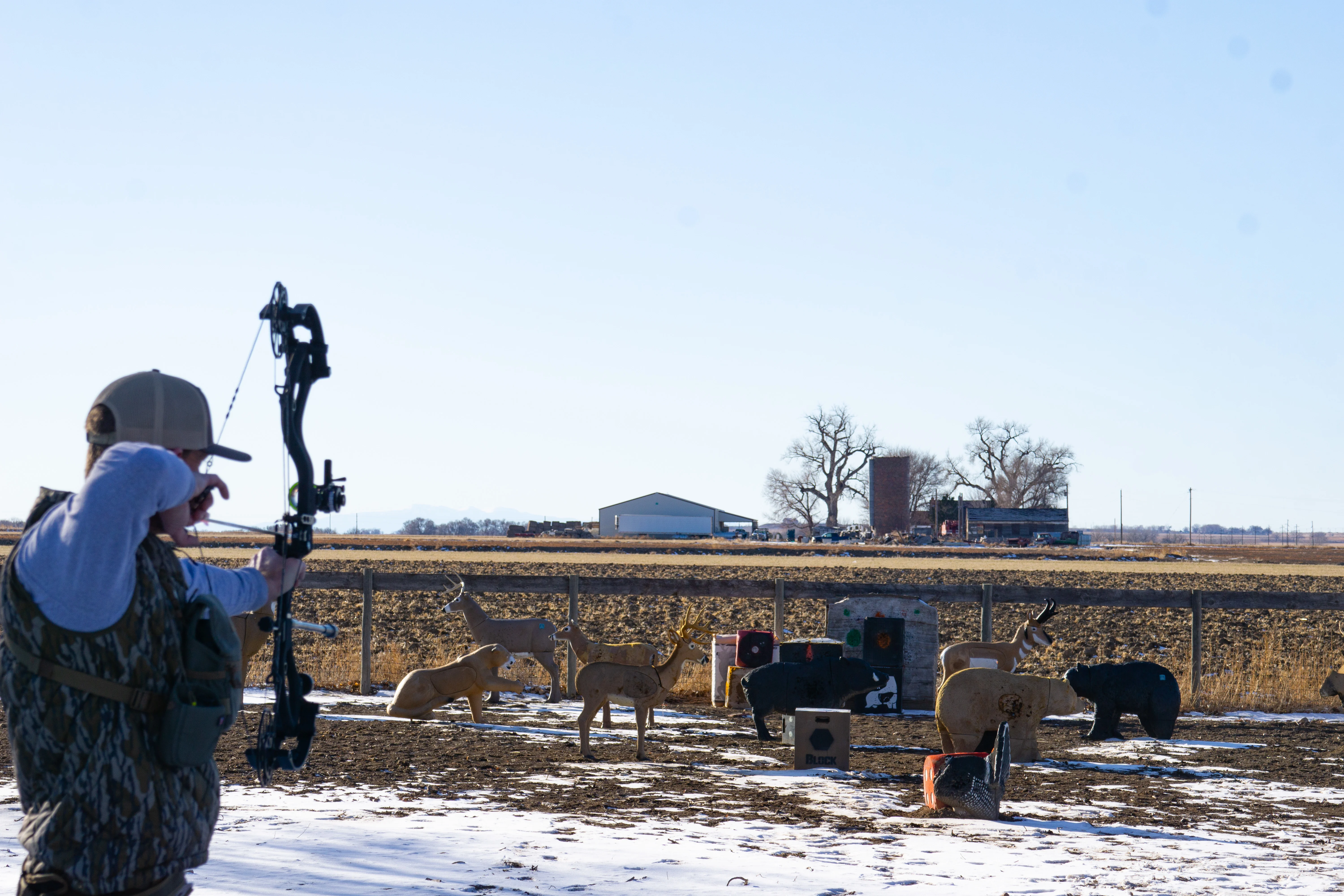 An archer shoots a bow at a group of 3D targets.