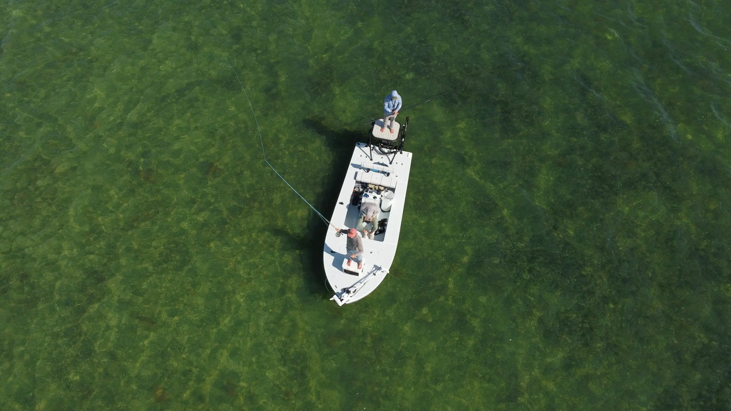 fly fisherman makes a cast off of a flats boat