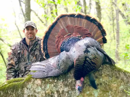 A hunter next to a large public land turkey.