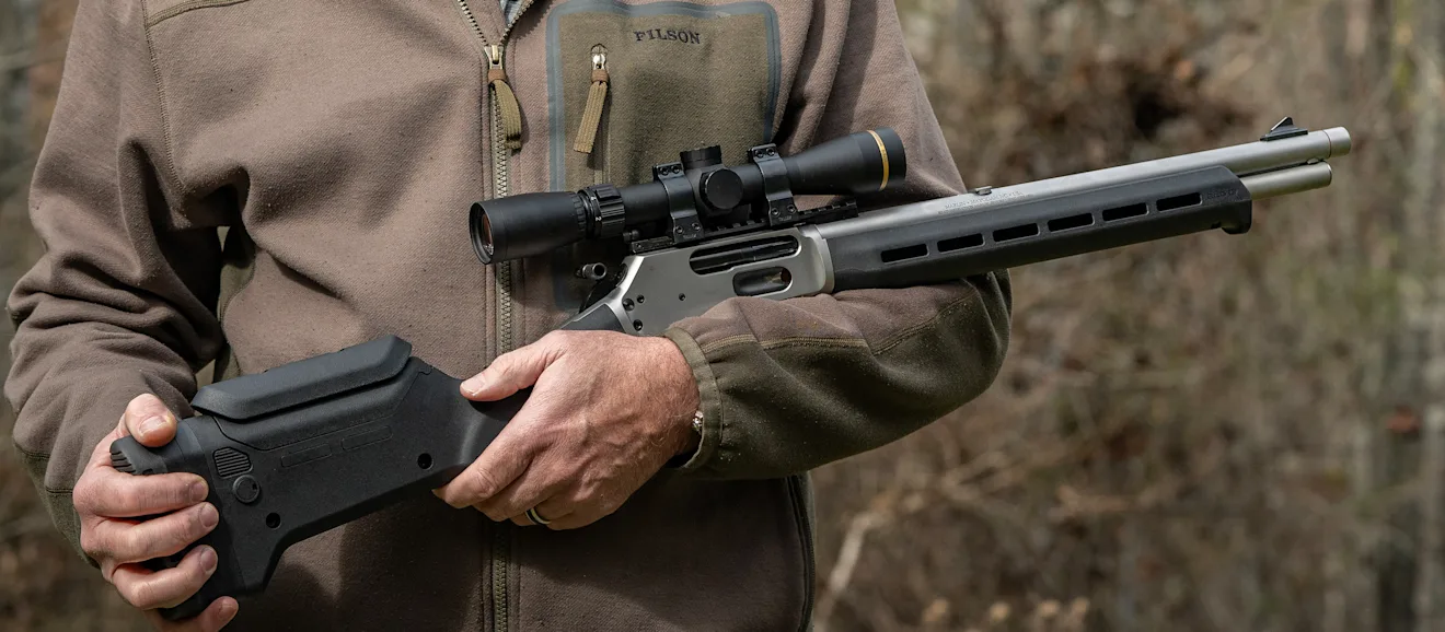 A shooter holds the new Marlin 1895 Trapper Magpul lever-action rifle cradled in his arms.