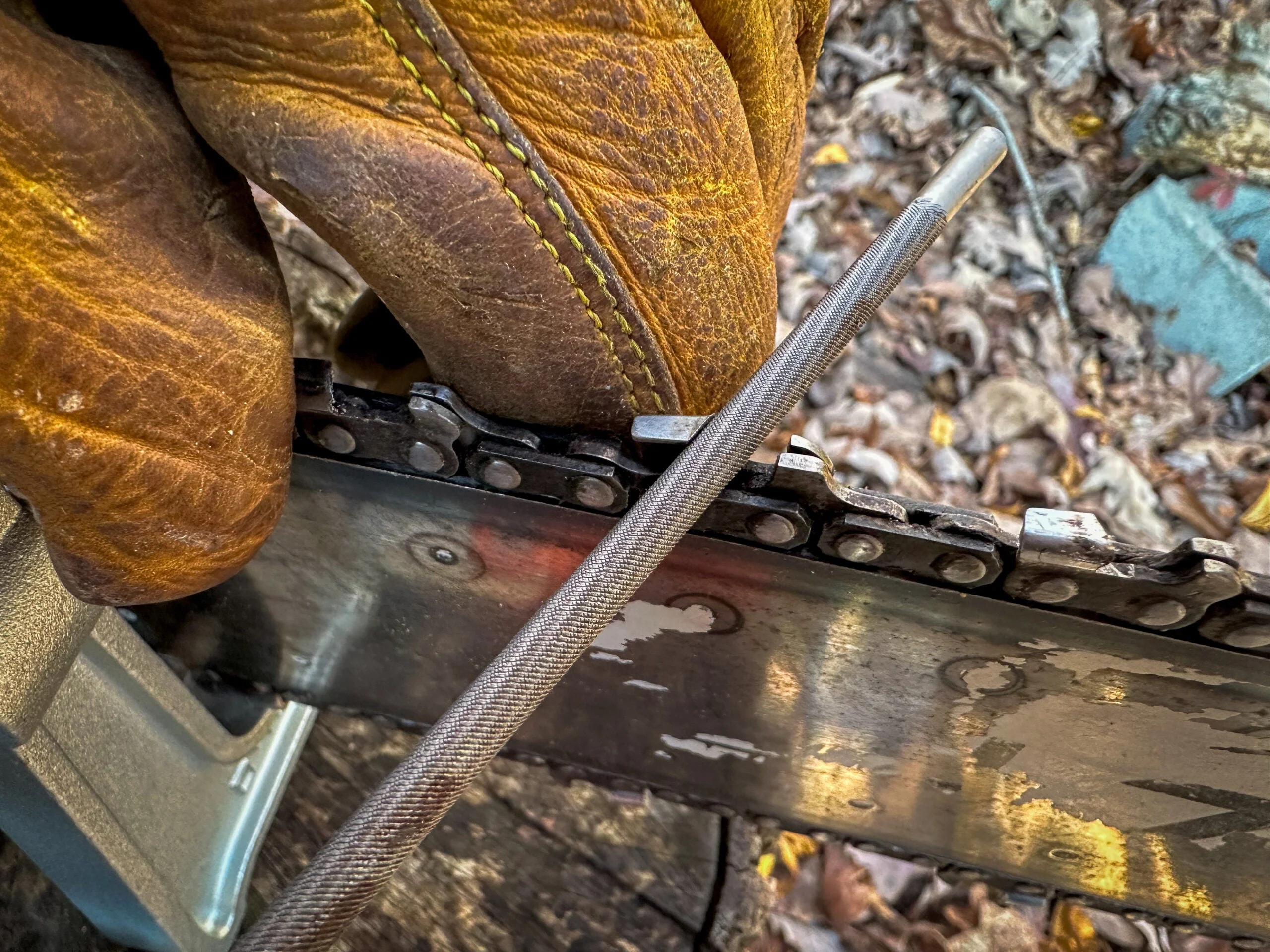 Using a file to sharpen a chainsaw