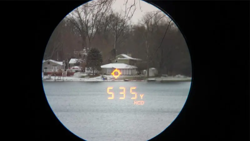 The view through a Vortex Razor HD 4000 of a house across a lake on a snowy day. 