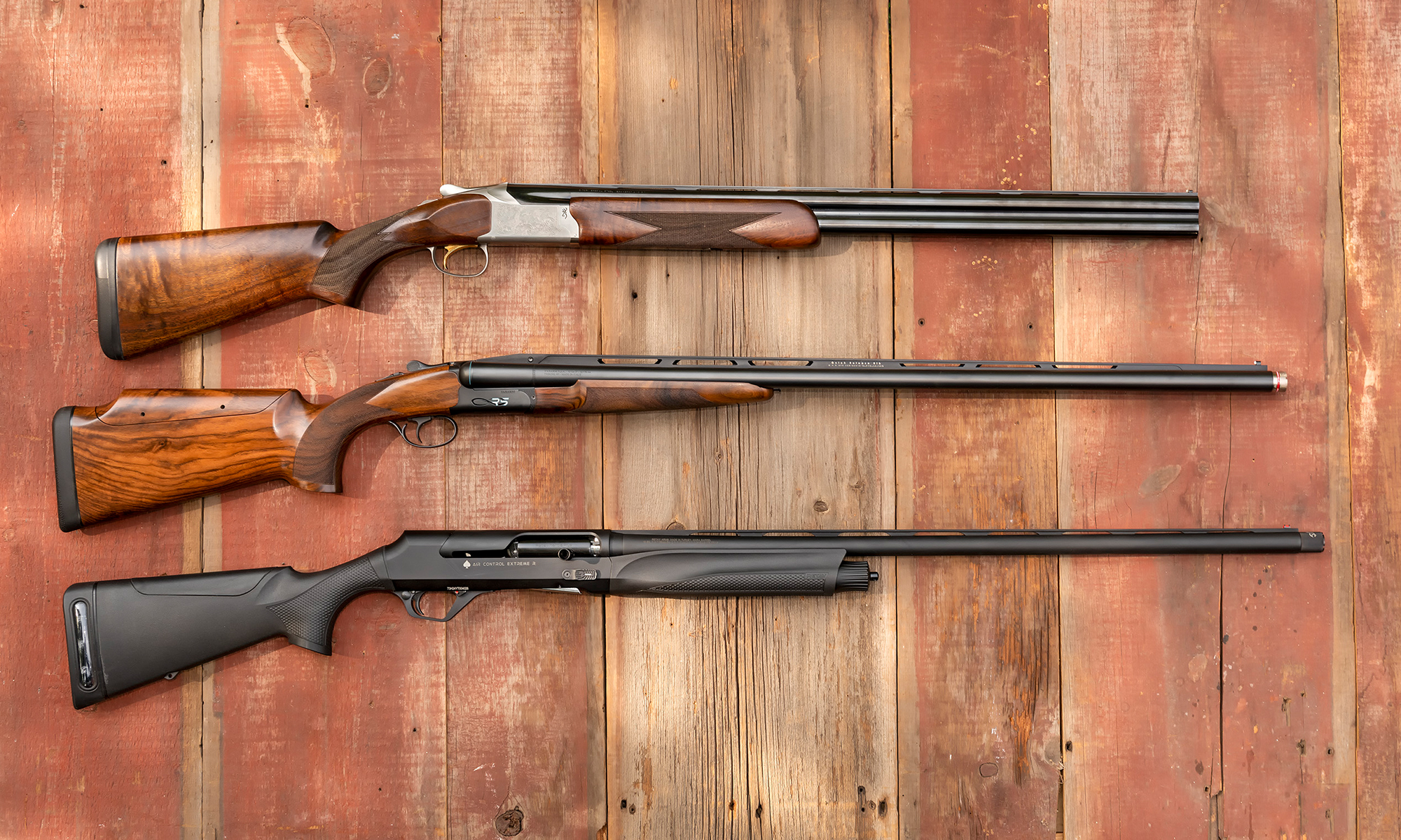 Three of the best shotguns of 2025 resting on barn boards.