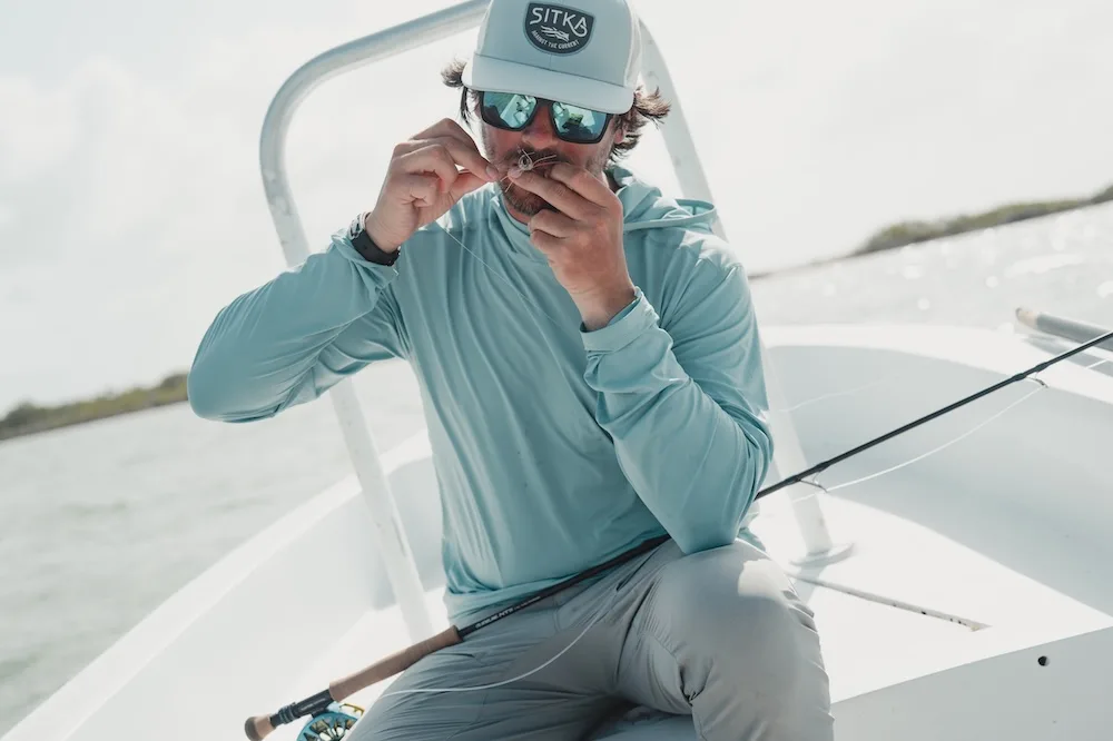 Angler wearing Sitka Guard Sun Hoodie on boat