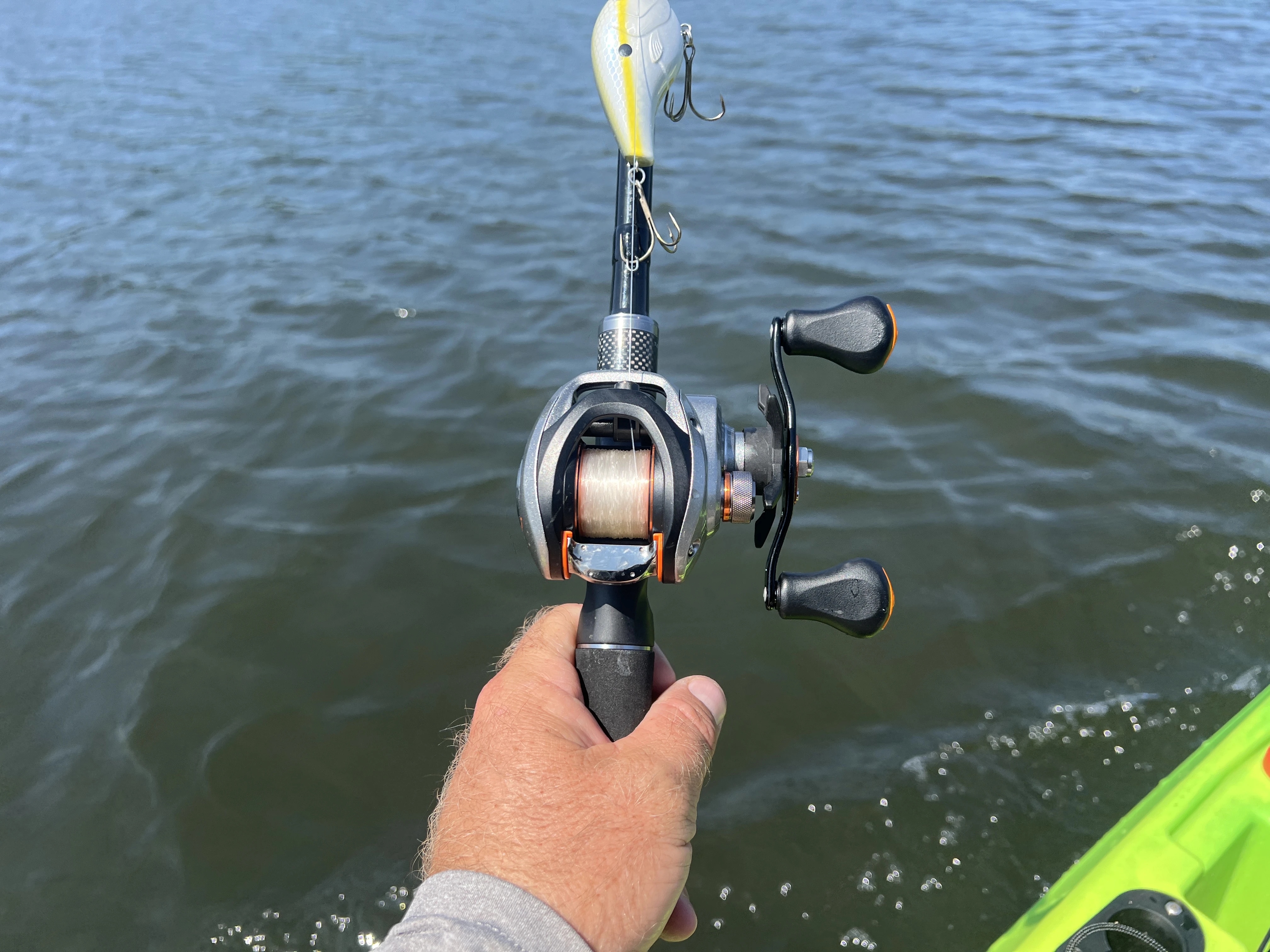 Angler's hand holding the Daiwa CA 80 casting reel.