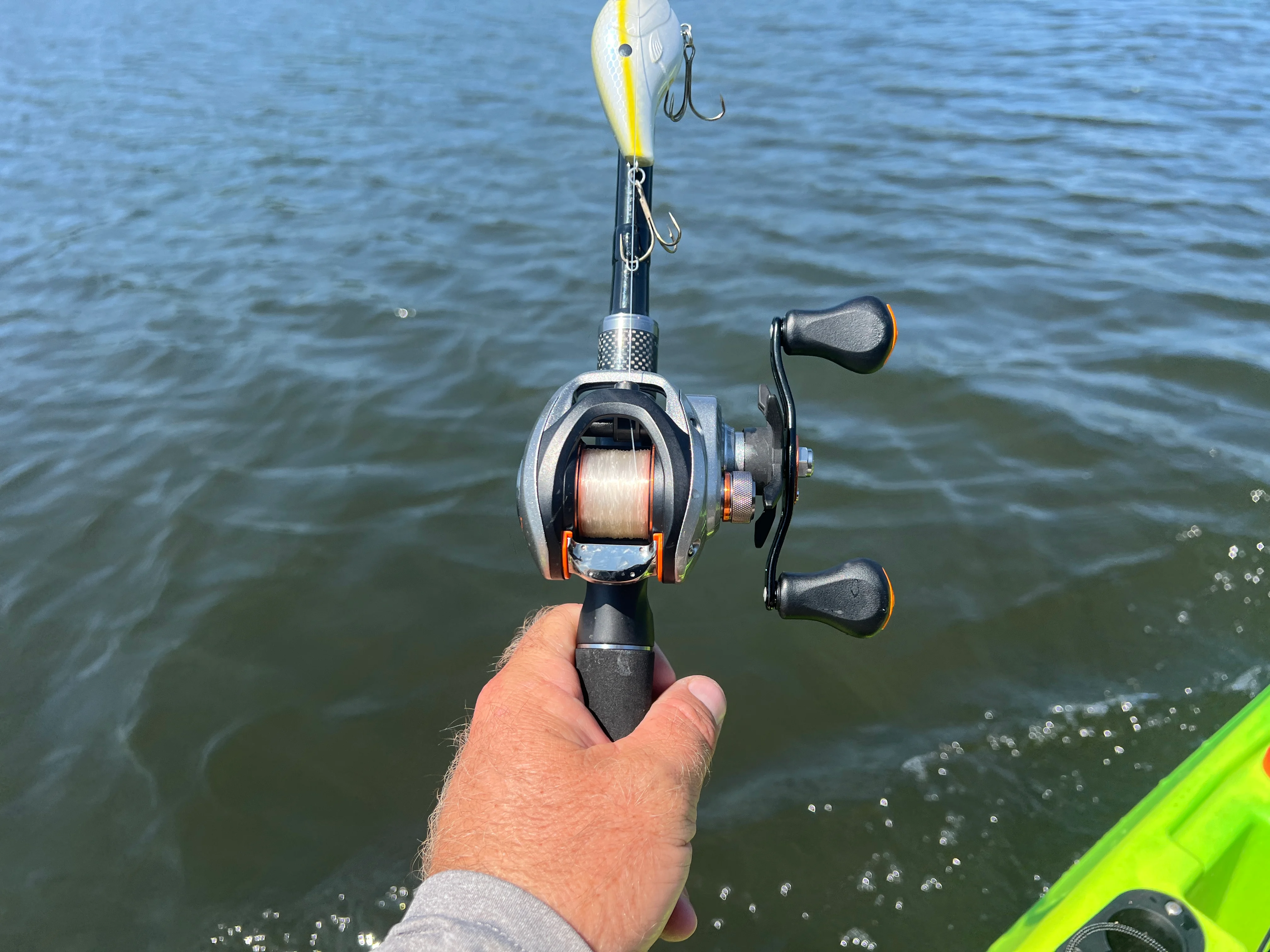 Angler's hand holding the Daiwa CA 80 casting reel.