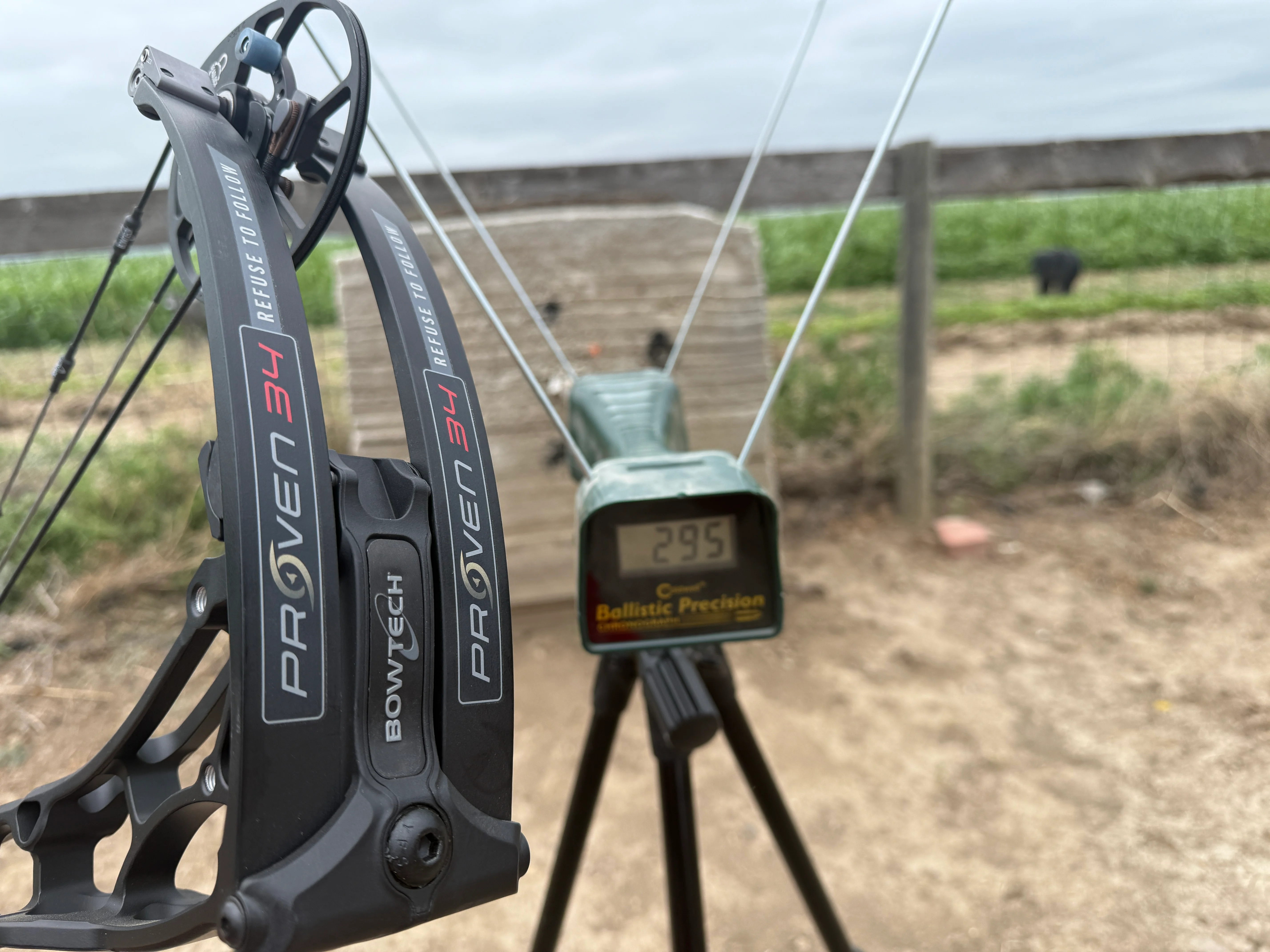 The new Bowtech Proven 34 bow next to a chronograph reading 295 fps. 