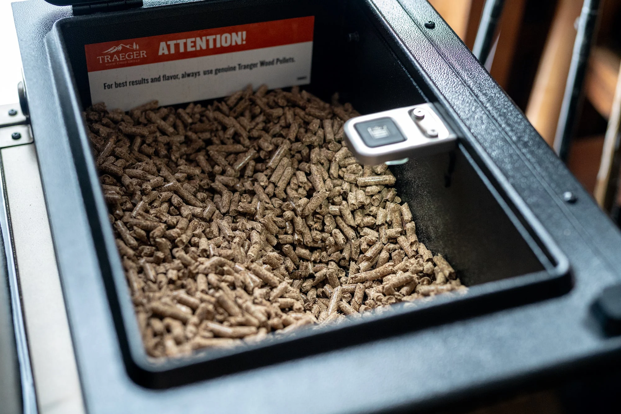 A pellet hopper on a Traeger pellet grill.