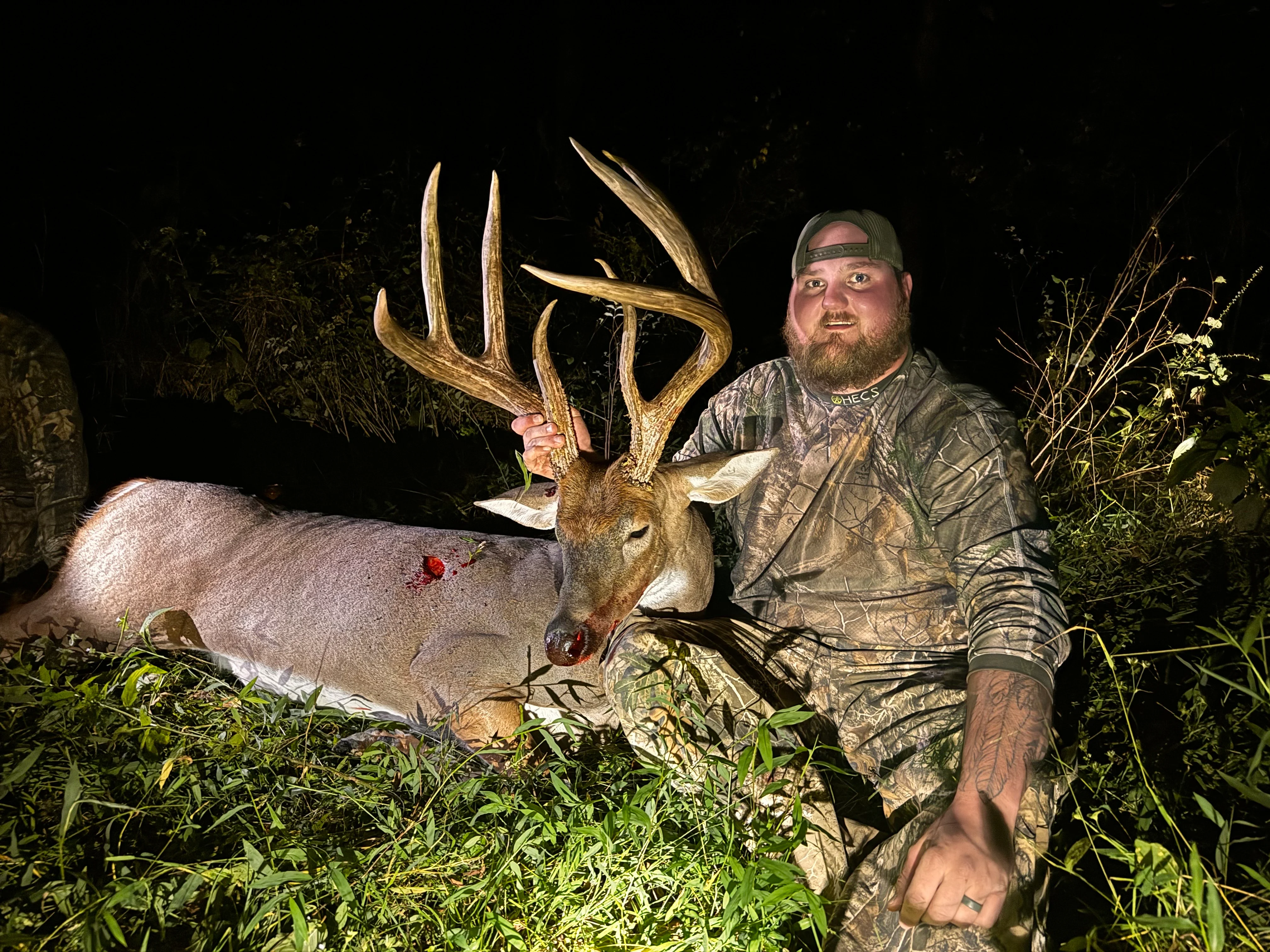 Kentucky hunter Brandon Burman postes at night with a big 8-point whitetail buck. 