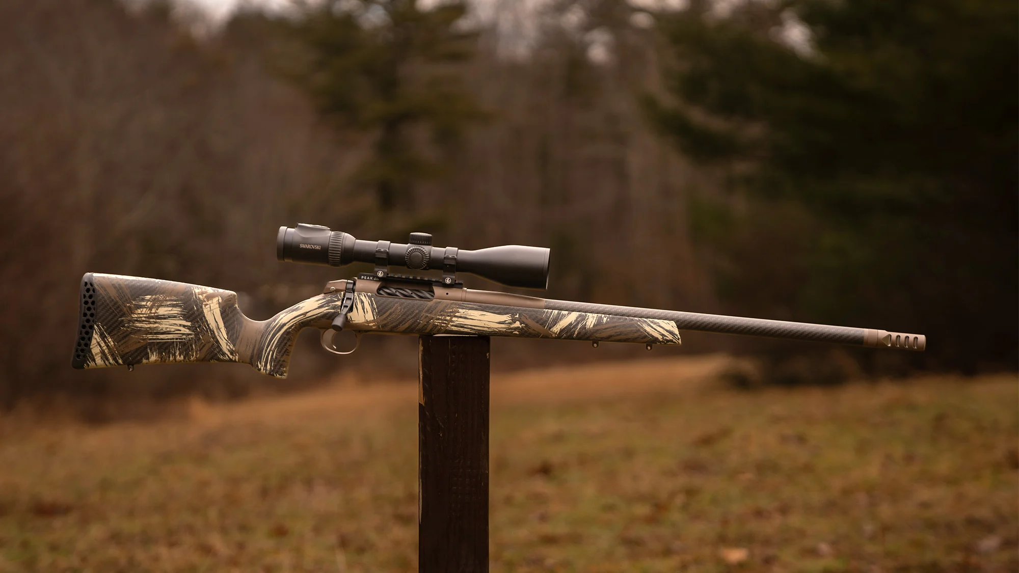 The new Weatherby Model 307 Alpine CT bolt-action rifle balanced on a post in a field. 