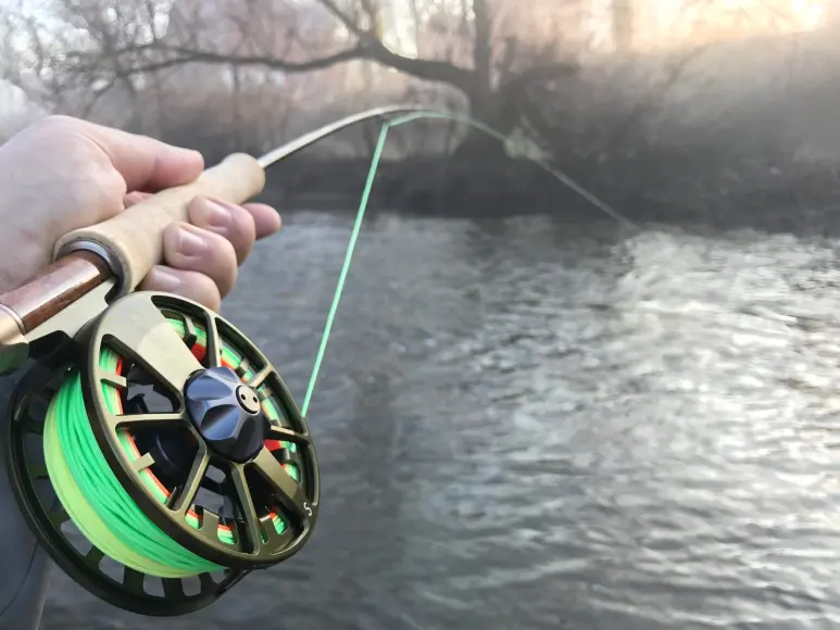 Fly fishing rod and reel on trout river