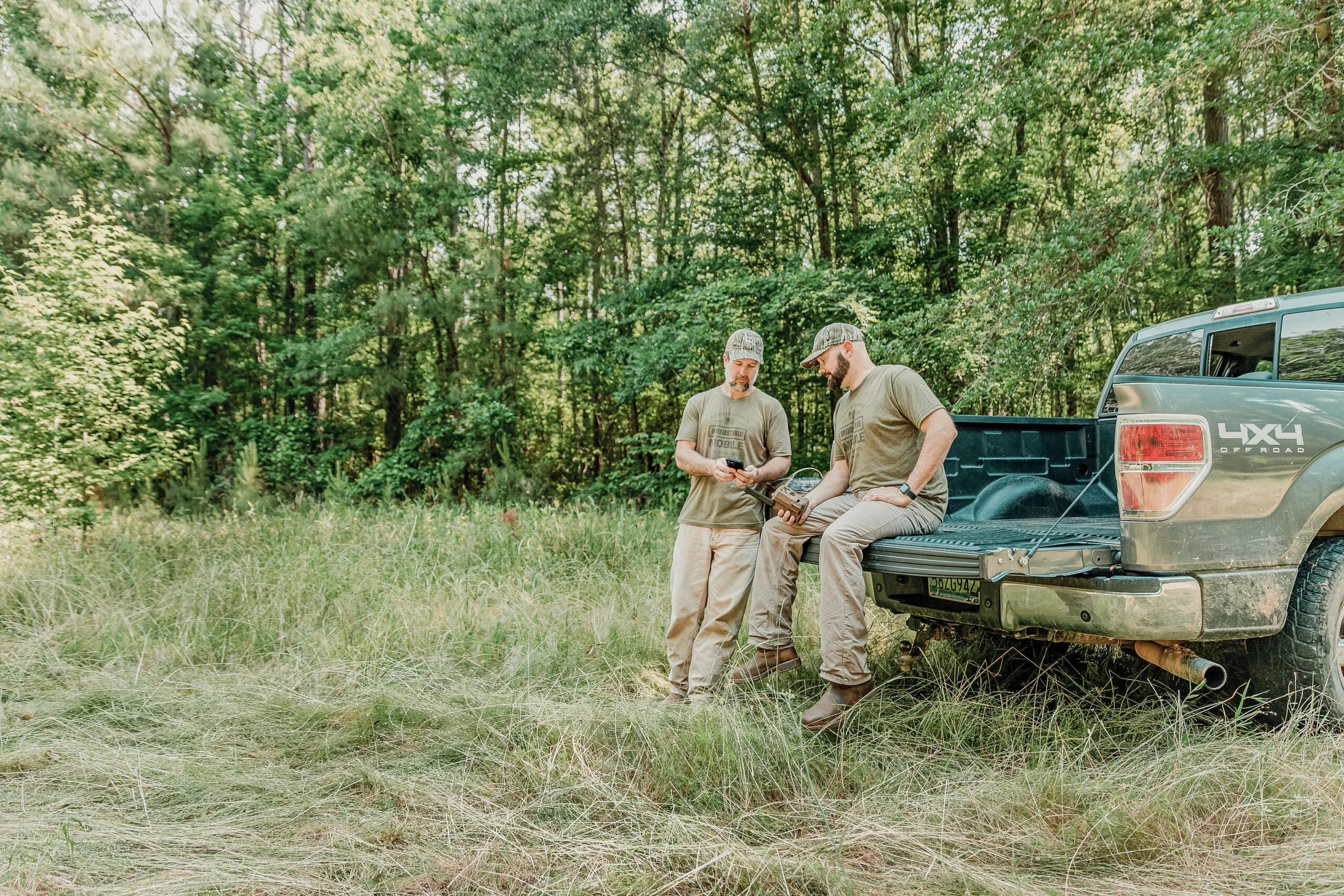 hunters looking at trail cam