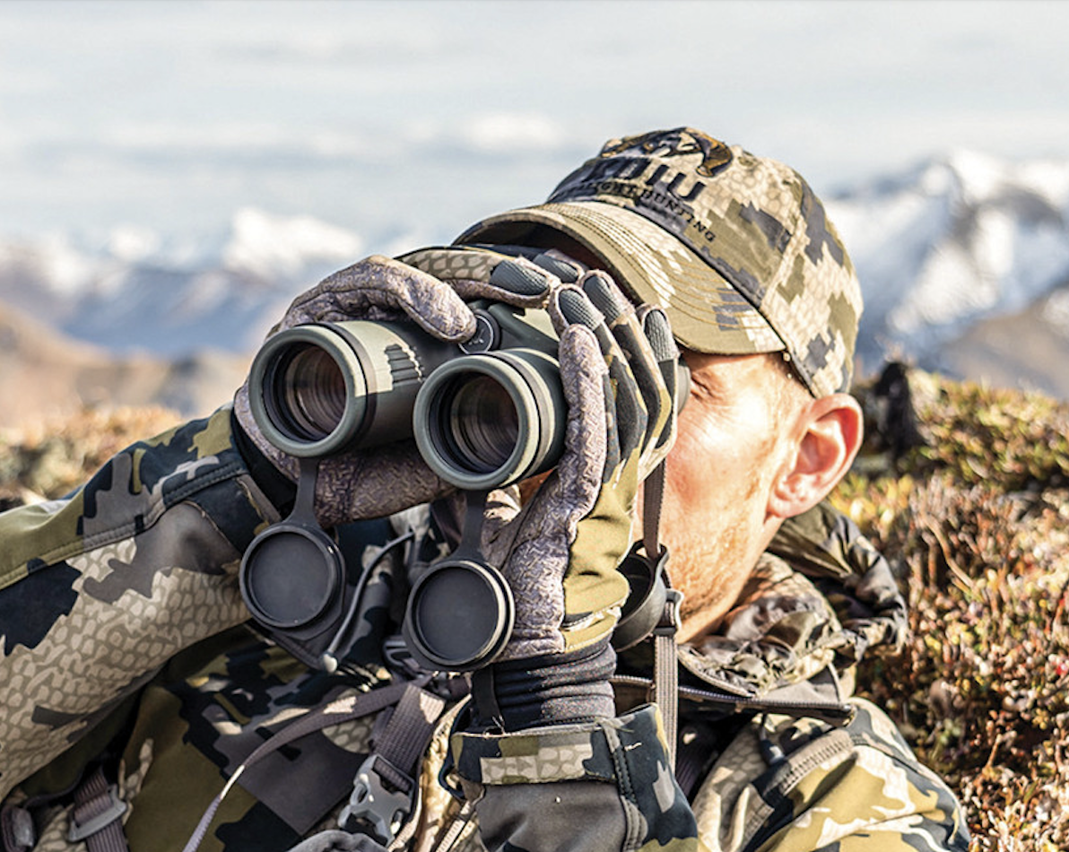 A hunter glassing with binoculars in the mountains. 