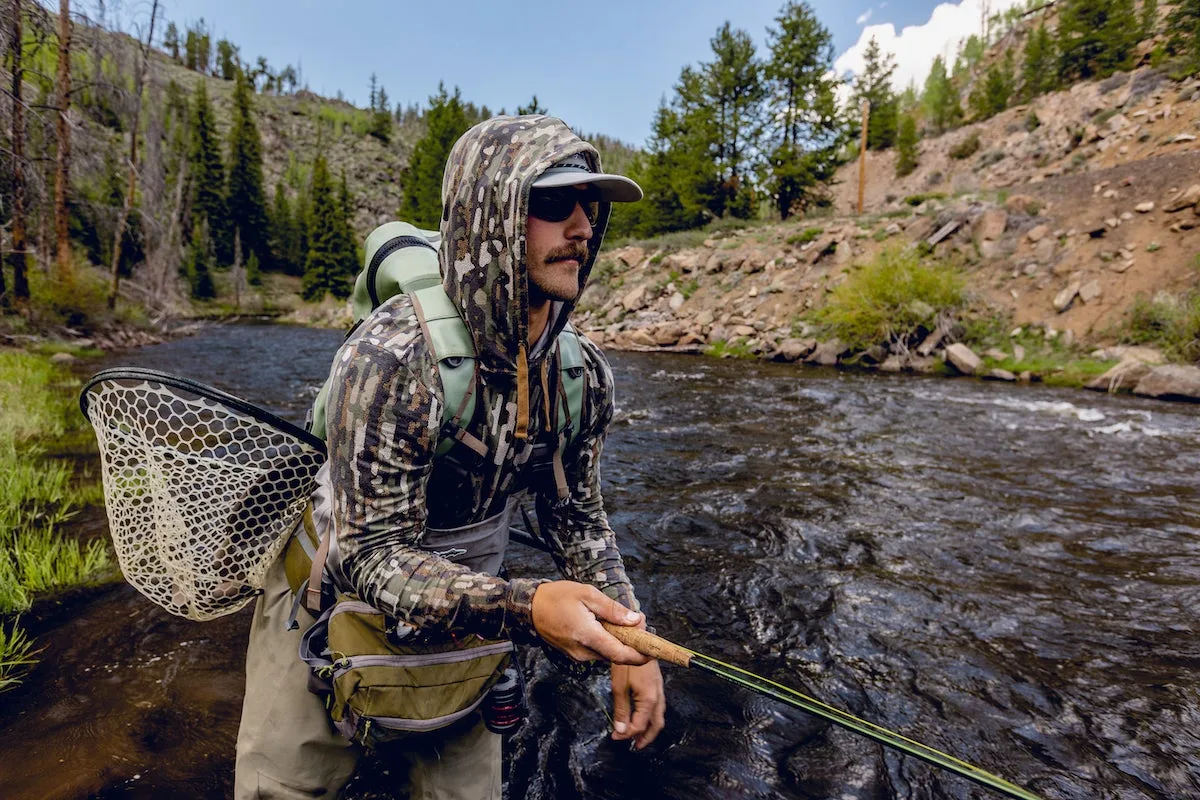 Angler fly fishing on the river wearing Duck Camp jacket