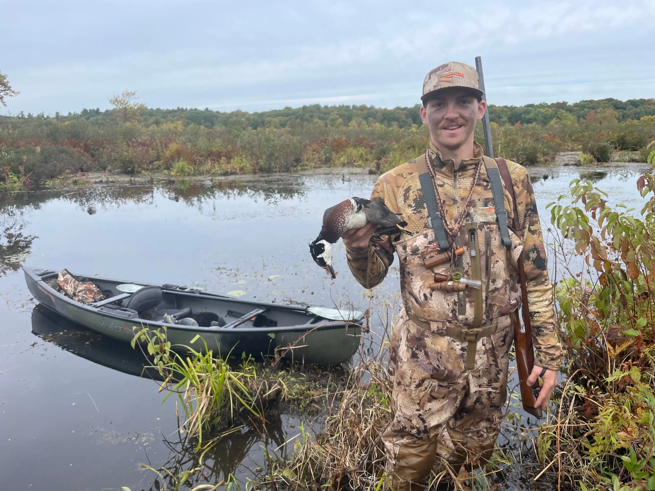 Me with a Hunter holding drake wood duck with Old Town Discovery 119 Solo Sportsman canoe