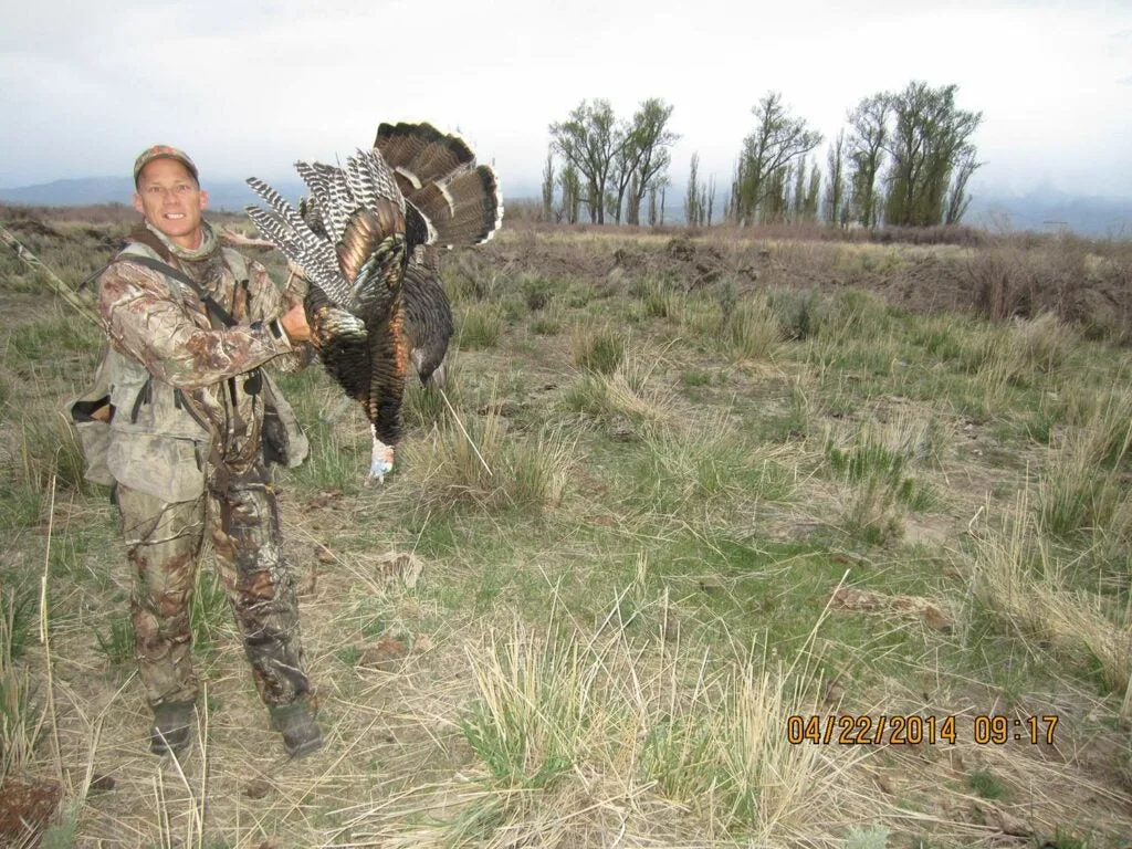 A hunter next to a large public land turkey.