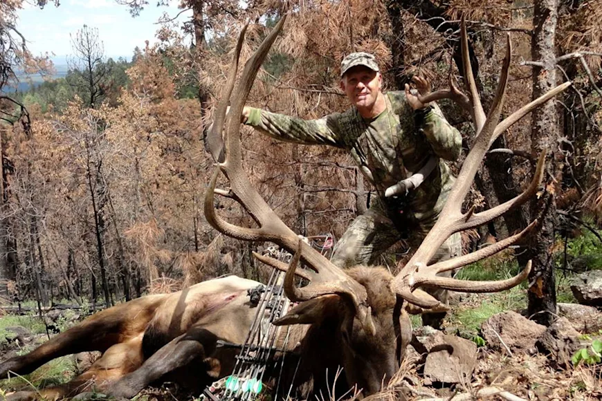 An elk hunter poses with a top-five archery elk.