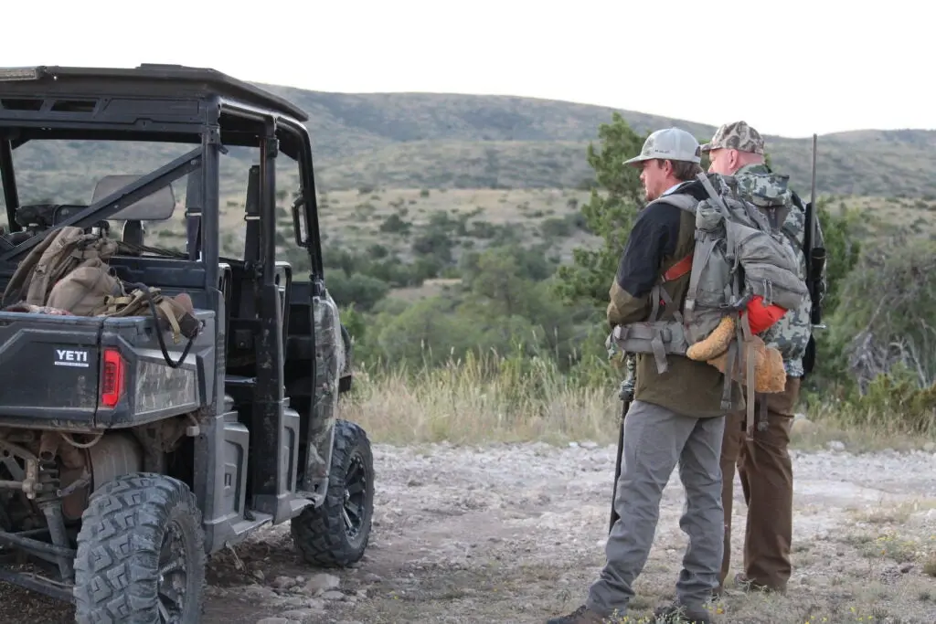 Hunters standing near a UTV.