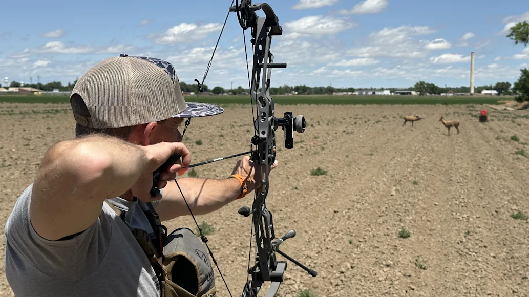 Man shooting Hoyt compound bow at target