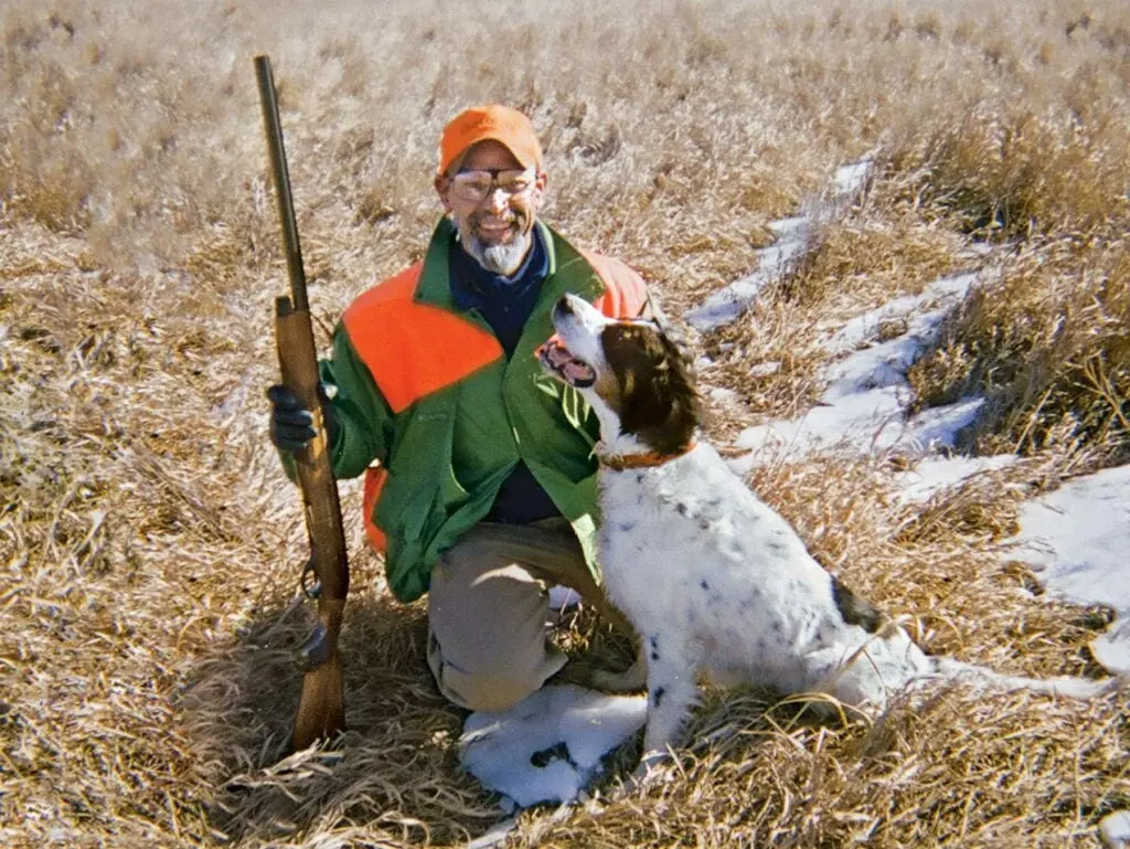 phil bourjaily kneeling beside hunting dog