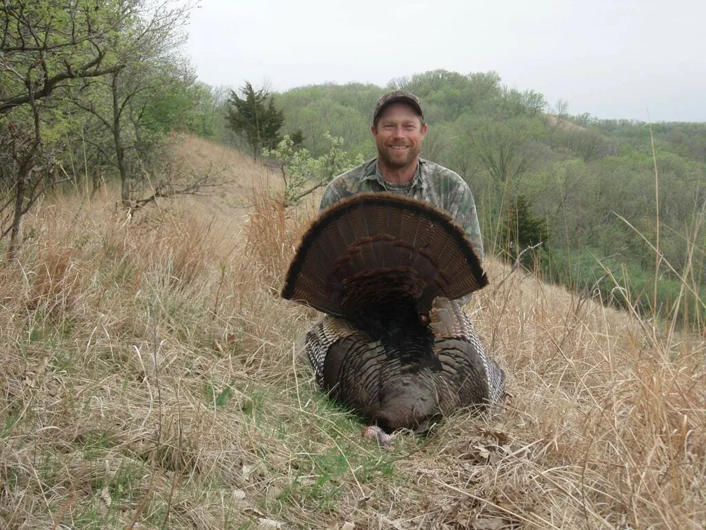 A hunter next to a large public land turkey.