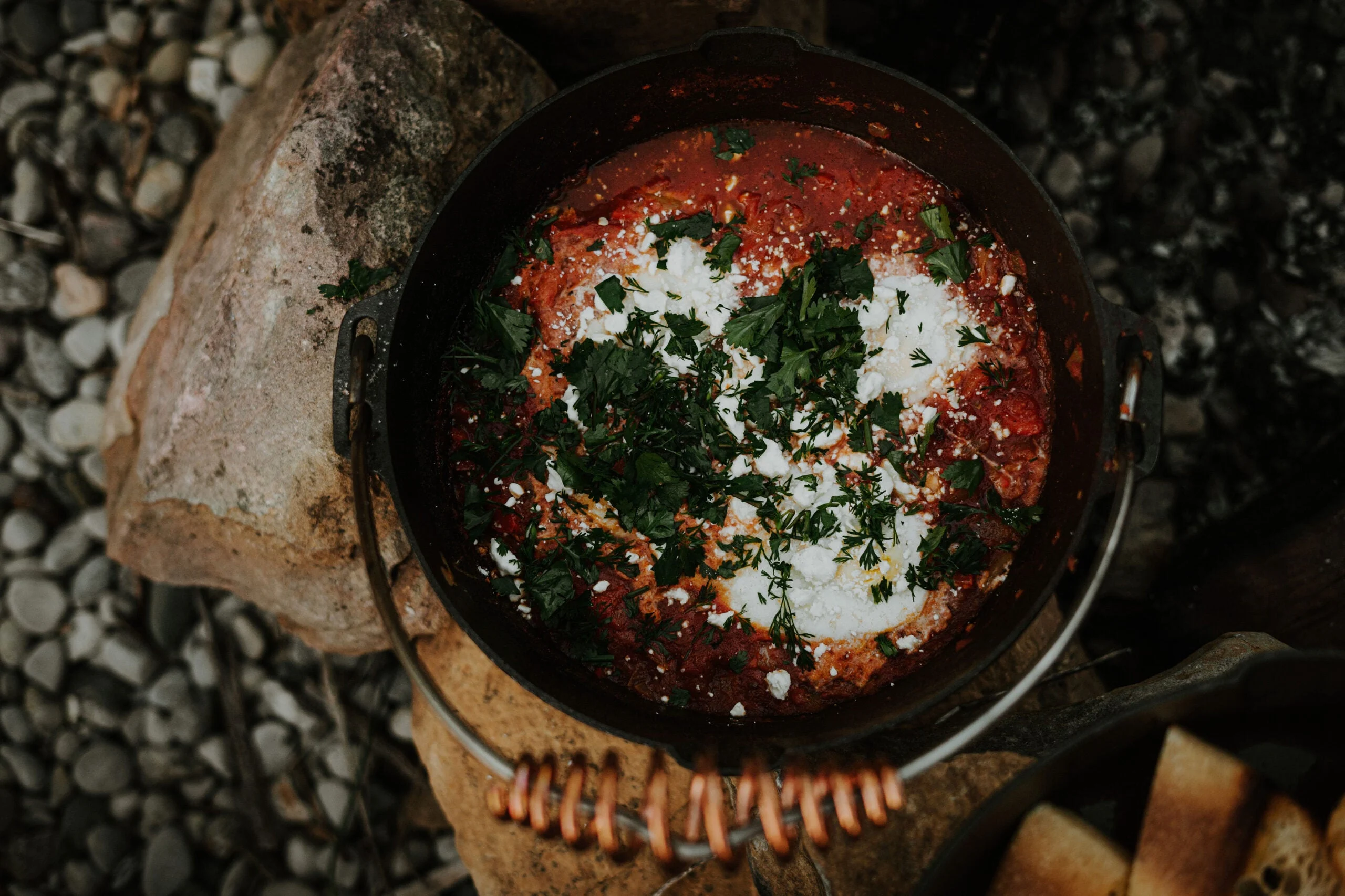 dutch oven on rocks with food inside