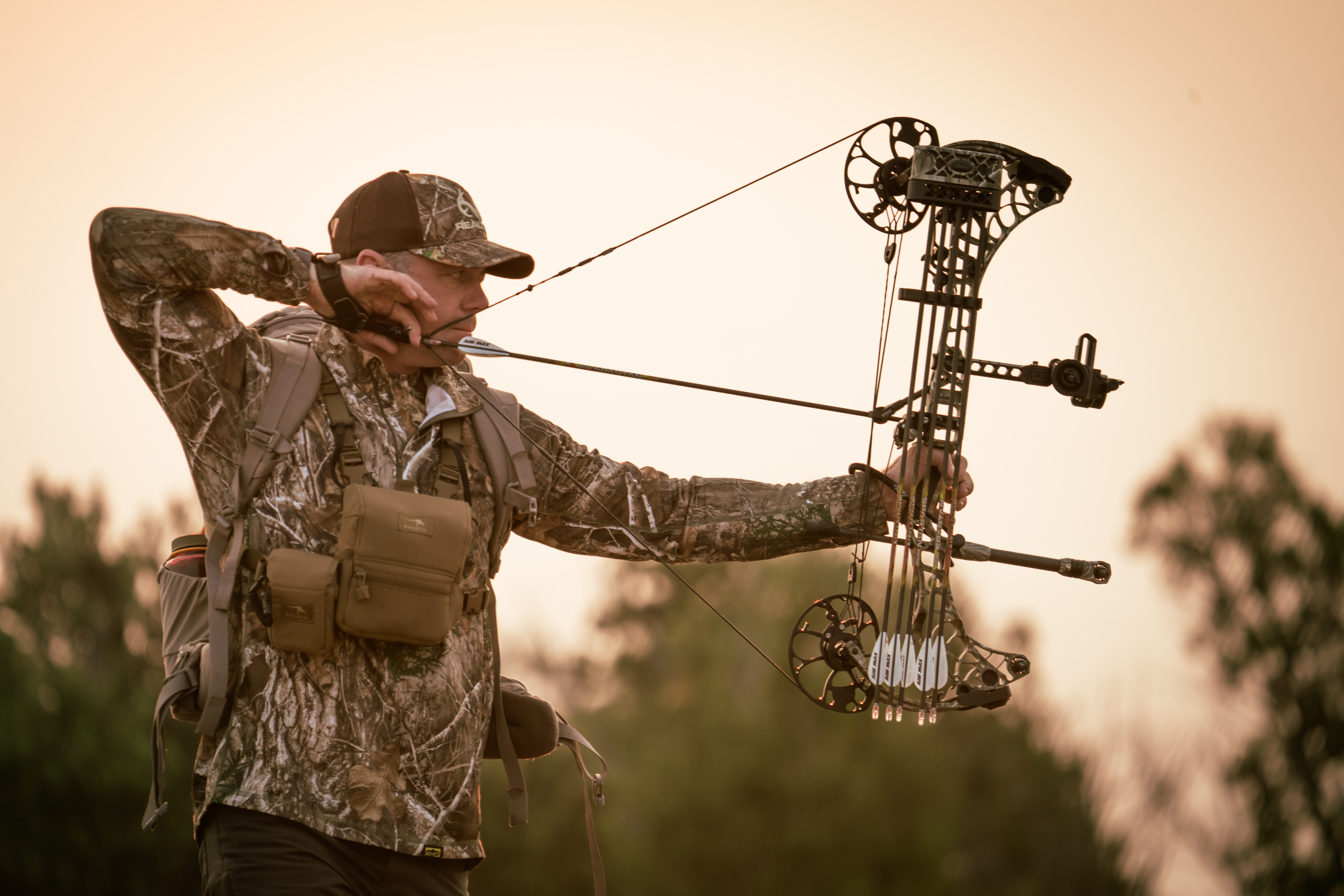 A hunter draws a compound bow, showing draw length.