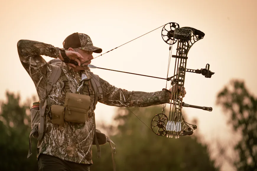 A hunter draws a compound bow, showing draw length.
