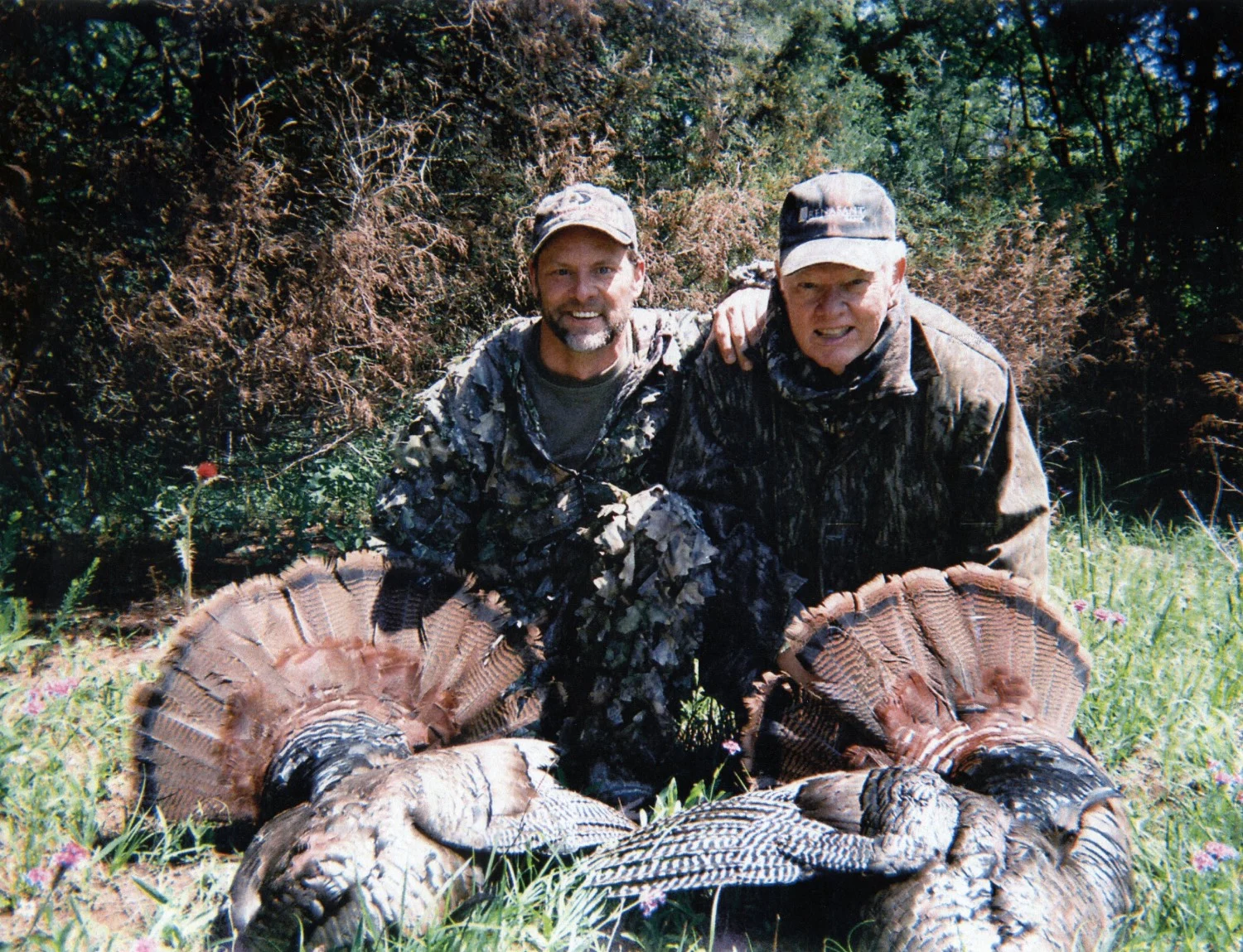 A father and son pose for a photo after a successful turkey hunt. 