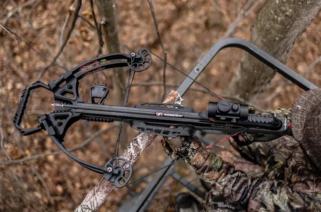 Hunter shooting Barnett crossbow from a tree stand